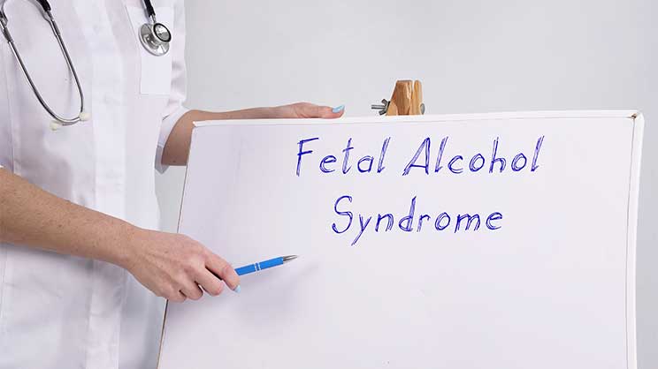 Doctor holding a sign - Fetal Alcohol Syndrome | From Childhood To Adulthood