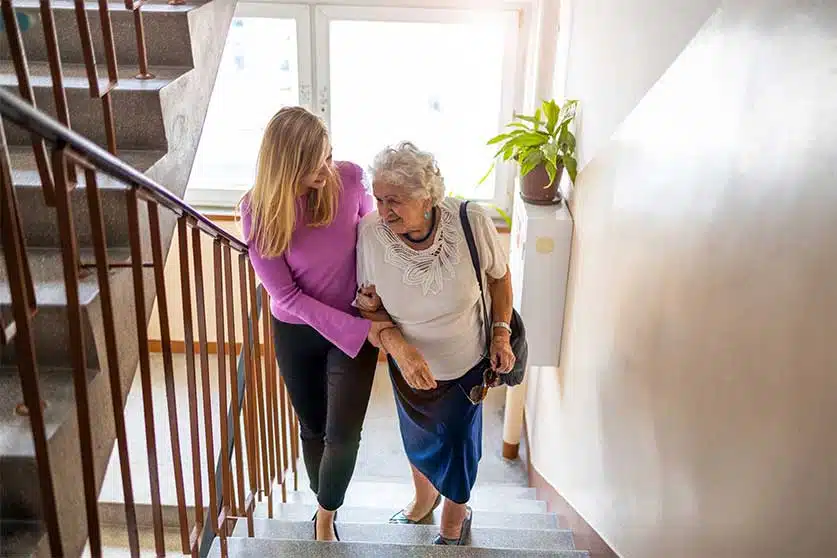 Woman Helping Elderly Lady Up Stairs-What Random Acts Of Kindness Mean For Addiction Recovery
