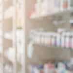 A blurred image of pill bottles on a pharmacy shelf - Is Vyvanse A Stimulant?