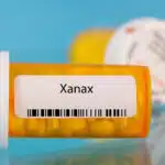 An orange prescription bottle with a label that reads "Xanax" - Xanax Side Effects Common, Severe, & Long-Term