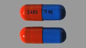 A blue and orange Vyvanse capsule with S489 and 70 mg printed on it