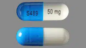A blue and white Vyvanse capsule with S489 and 50 mg printed on it