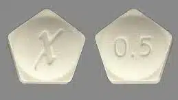 a pentagon shaped Xanax pill with an X and a 0.5 imprinted into it