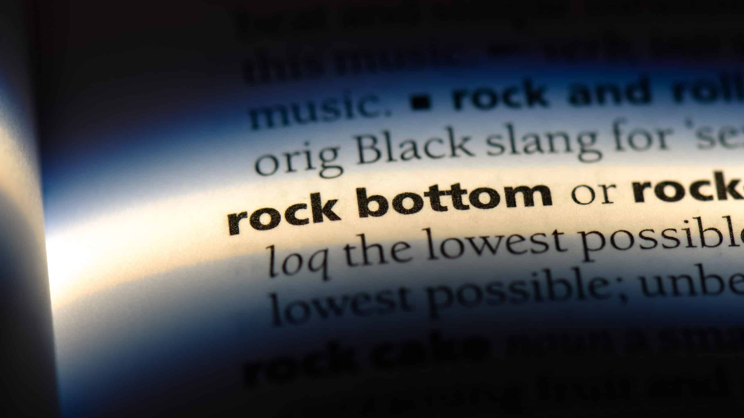 A dictionary page with the the words "rock bottom" highlighted with light - Do You Need To Hit Rock Bottom Before Getting Sober