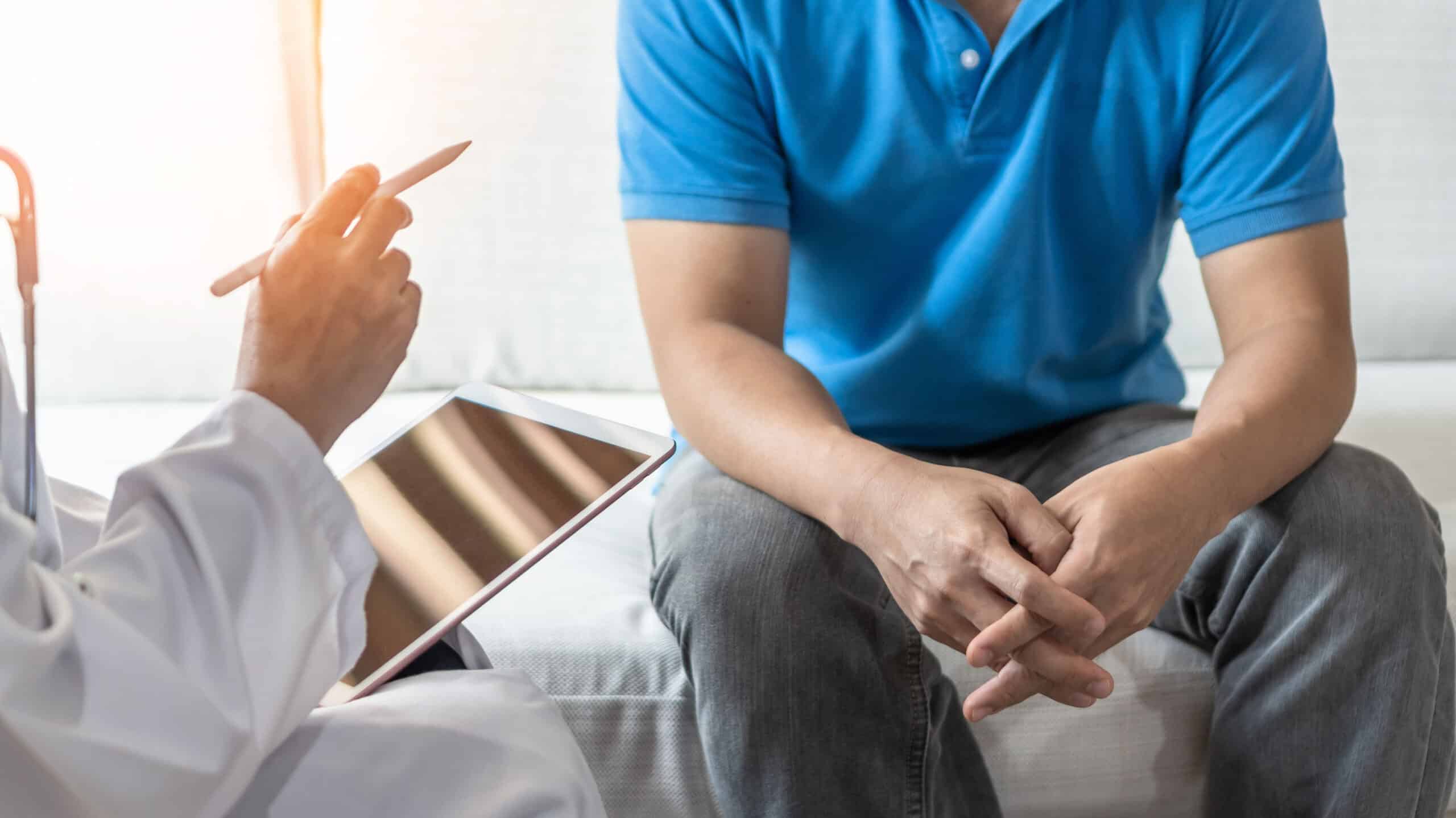A man speaks to a doctor holding a tablet - What Is A Substance Abuse Treatment Plan