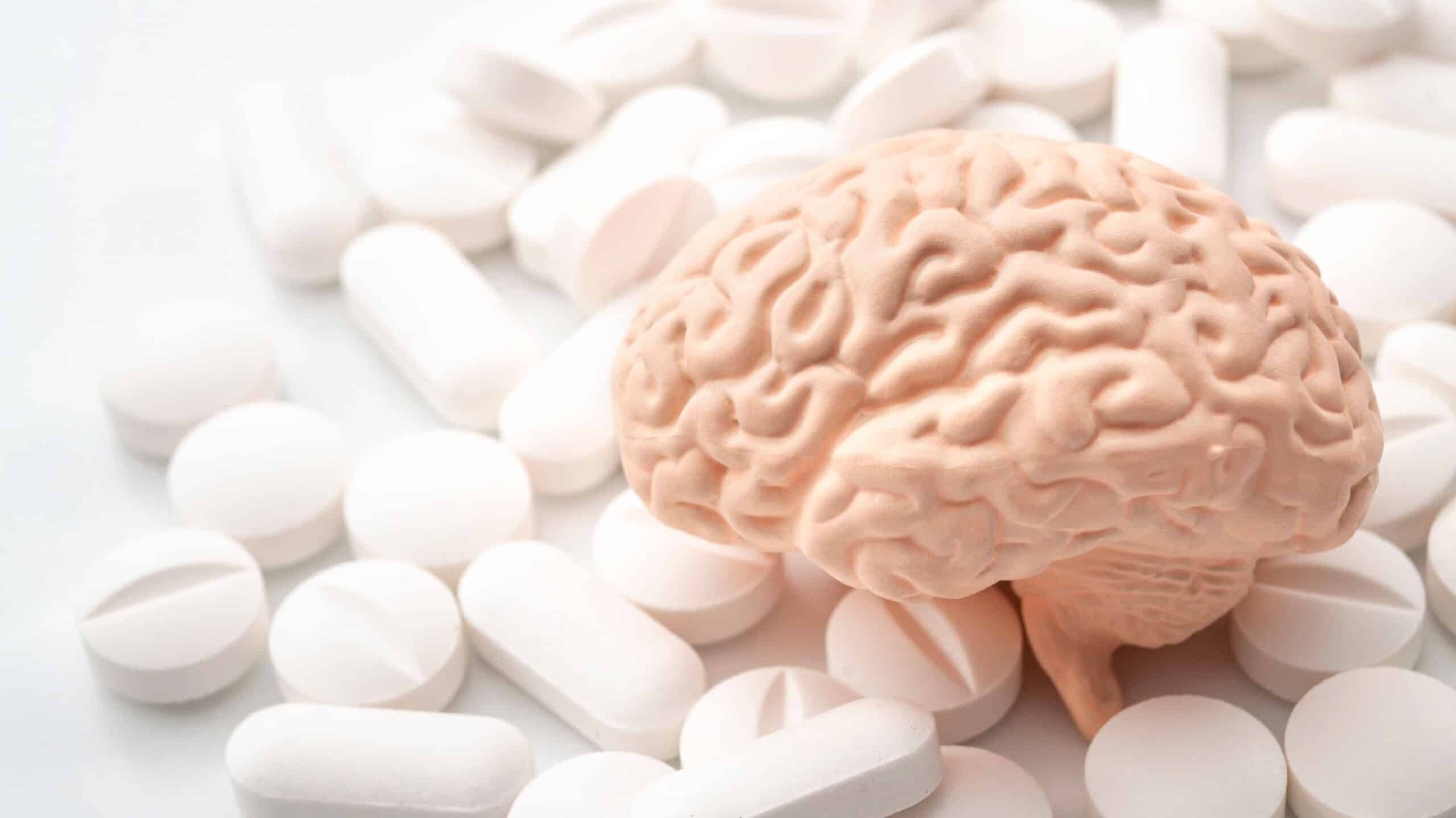 A toy brain sits on a pile of pills - How Alcohol & Drug Misuse Affects Mental Health